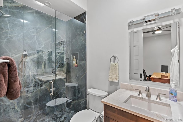 bathroom featuring vanity, ceiling fan, a shower with shower door, and toilet