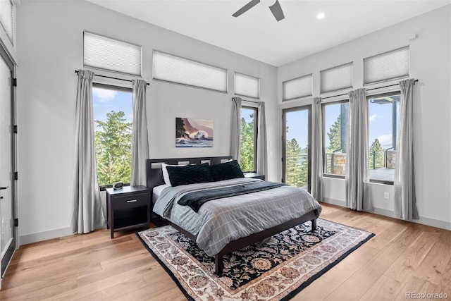 bedroom featuring light hardwood / wood-style flooring, multiple windows, and ceiling fan