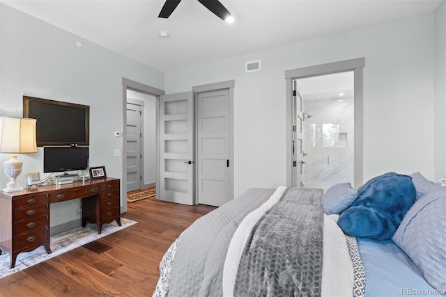 bedroom with ensuite bath, ceiling fan, and dark hardwood / wood-style flooring