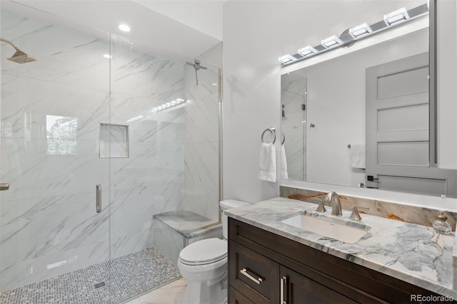 bathroom with vanity, a shower with shower door, and toilet