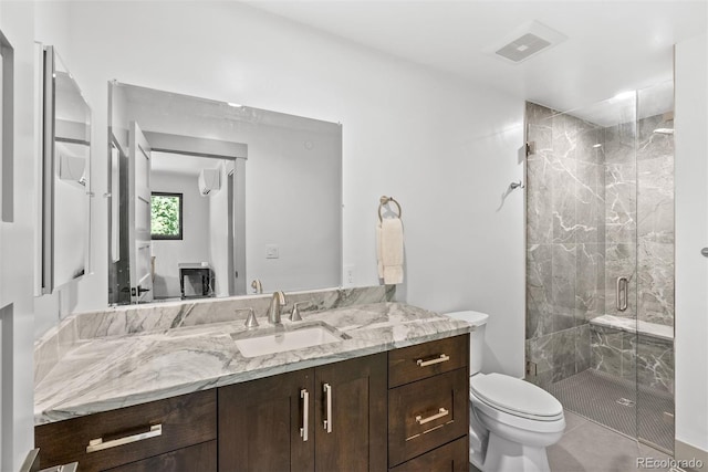 bathroom with walk in shower, vanity, toilet, and tile patterned floors