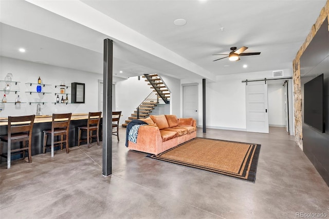 living room featuring concrete floors, bar area, and a barn door