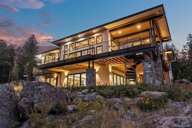 back house at dusk with a balcony