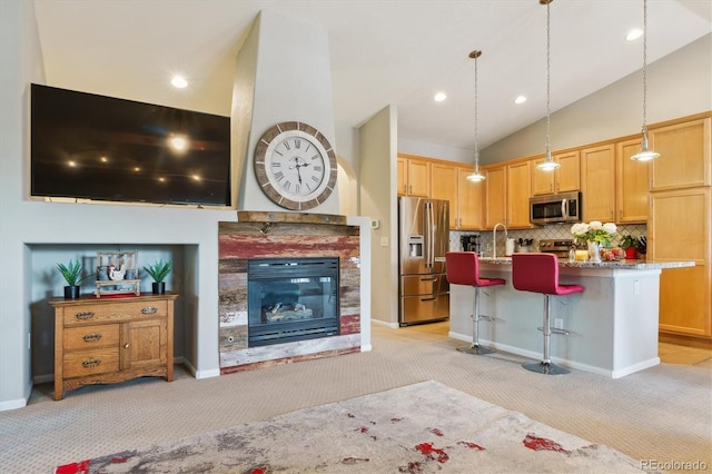 22932 E Ontario Dr Unit 102, Aurora, CO 80016 - kitchen with appliances with stainless steel finishes, light carpet, tasteful backsplash, a breakfast bar, and a sink