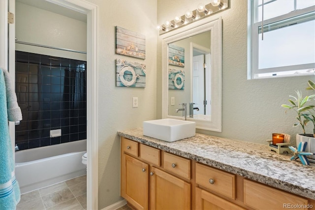 22932 E Ontario Dr Unit 102, Aurora, CO 80016 - bathroom featuring vanity, a textured wall, toilet, and bathing tub / shower combination