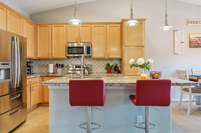22932 E Ontario Dr Unit 102, Aurora, CO 80016 - kitchen with stainless steel appliances, a kitchen island with sink, a breakfast bar, decorative backsplash, and lofted ceiling