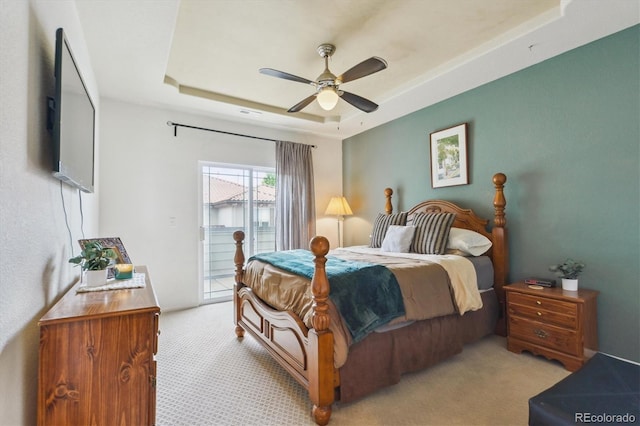 22932 E Ontario Dr Unit 102, Aurora, CO 80016 - bedroom featuring access to exterior, light colored carpet, a tray ceiling, and ceiling fan