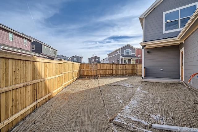 view of yard featuring a residential view, a fenced backyard, and a patio area