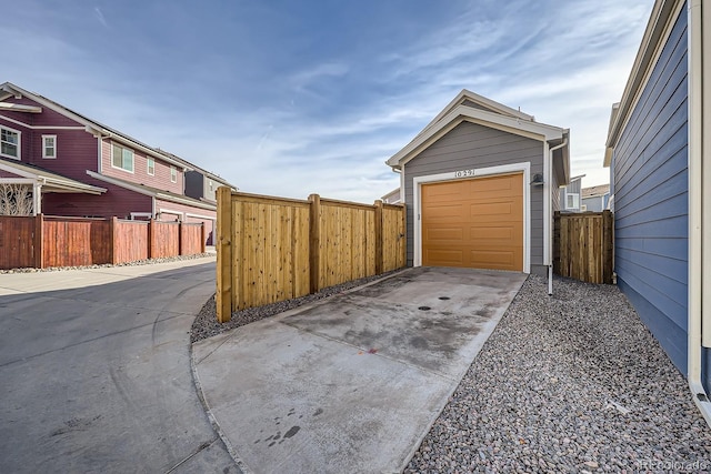 garage featuring driveway and fence