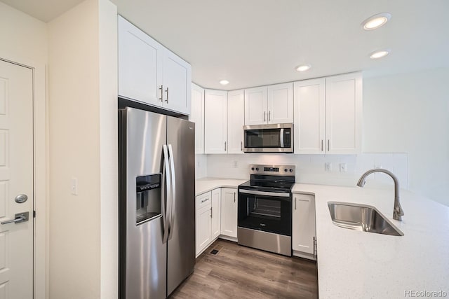 kitchen with a sink, decorative backsplash, white cabinets, and stainless steel appliances