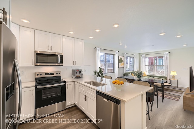 kitchen featuring a sink, decorative backsplash, appliances with stainless steel finishes, and white cabinets