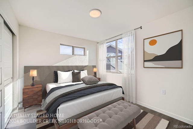 bedroom featuring wood finished floors, baseboards, and a closet