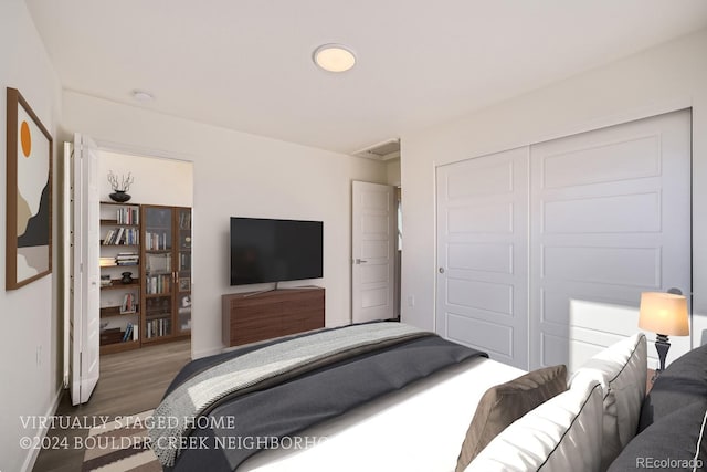 bedroom featuring wood finished floors, a closet, and baseboards