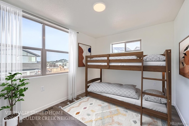 bedroom with visible vents, baseboards, and wood finished floors