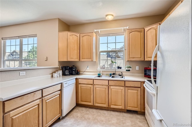 kitchen featuring white appliances, light brown cabinetry, sink, and light tile patterned flooring