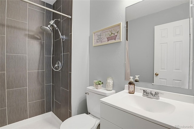 2185 Ambleside Dr, Colorado Springs, CO 80915 - bathroom featuring toilet, tiled shower, and vanity
