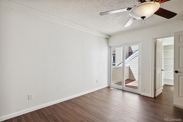 unfurnished room with a textured ceiling, ceiling fan, and dark wood-type flooring