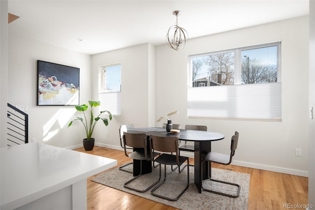 dining room featuring plenty of natural light, light wood-type flooring, and baseboards