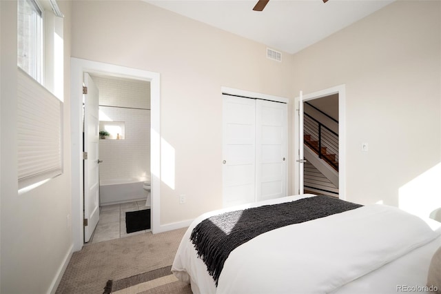 bedroom with visible vents, ensuite bath, a closet, carpet flooring, and baseboards