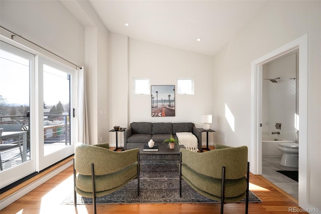 living area with recessed lighting, lofted ceiling, and wood finished floors