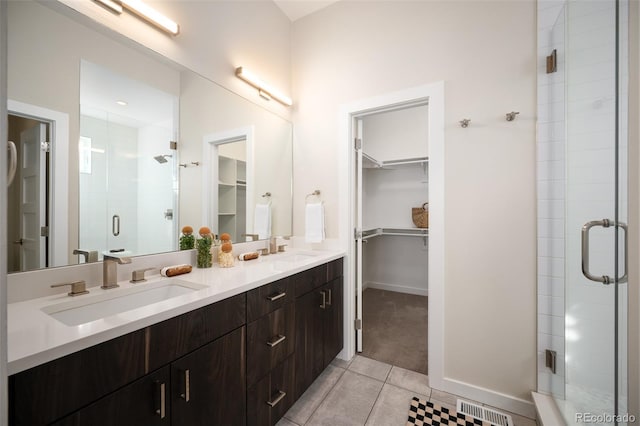 bathroom featuring a sink, visible vents, a shower stall, and tile patterned flooring