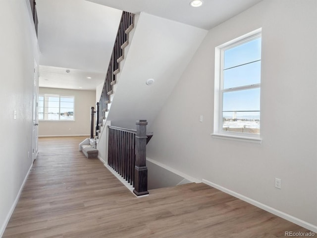 staircase featuring wood-type flooring and lofted ceiling