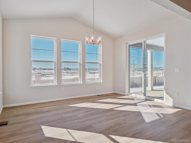 unfurnished room featuring vaulted ceiling, light hardwood / wood-style flooring, and an inviting chandelier