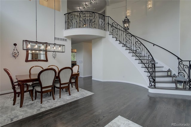 10609 Chadsworth Ln, Highlands Ranch, CO 80126 - dining area featuring dark wood finished floors, a towering ceiling, stairs, baseboards, and a chandelier