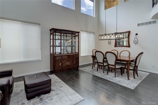 10609 Chadsworth Ln, Highlands Ranch, CO 80126 - dining area featuring a high ceiling, dark wood-style floors, baseboards, and a chandelier