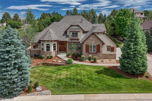 9121 Sunshine Meadow Pl, Parker, CO 80134 - view of front facade with stone siding, stucco siding, a front yard, and roof with shingles