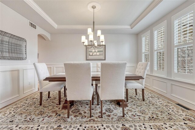 9121 Sunshine Meadow Pl, Parker, CO 80134 - dining area featuring a decorative wall, crown molding, a tray ceiling, a chandelier, and wainscoting