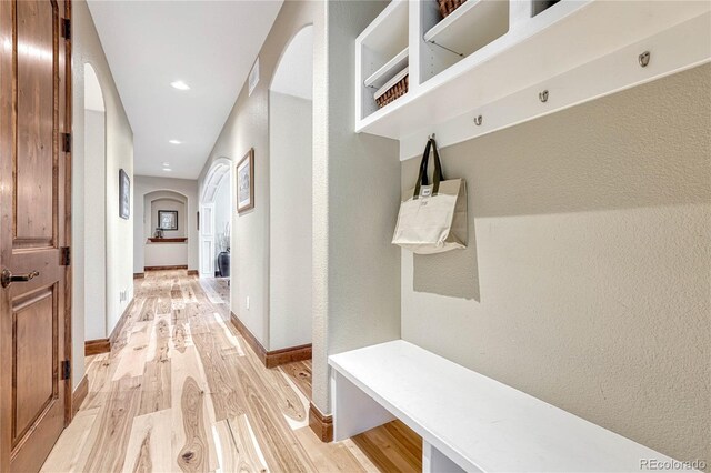 9121 Sunshine Meadow Pl, Parker, CO 80134 - mudroom with arched walkways, light wood finished floors, recessed lighting, and baseboards