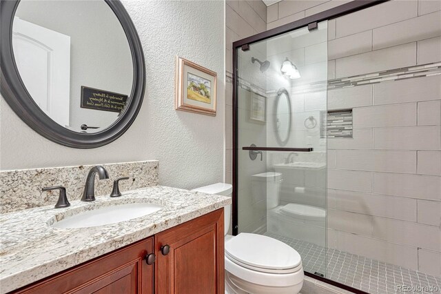 9121 Sunshine Meadow Pl, Parker, CO 80134 - bathroom with toilet, a textured wall, a stall shower, and vanity