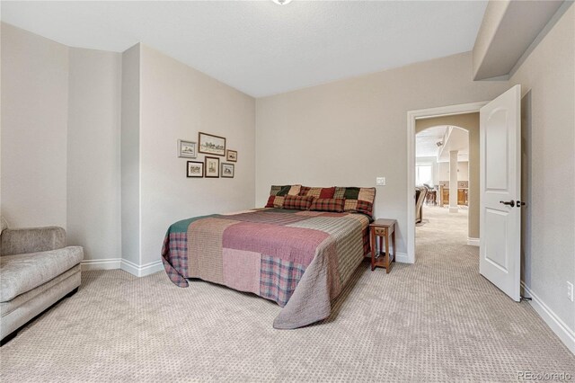 9121 Sunshine Meadow Pl, Parker, CO 80134 - bedroom with light colored carpet, arched walkways, and baseboards