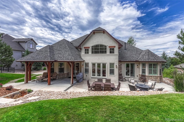 9121 Sunshine Meadow Pl, Parker, CO 80134 - rear view of property featuring stucco siding, a lawn, and a fire pit