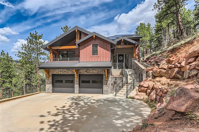 795 Pine Brook Rd, Boulder, CO 80304 - view of front of home featuring board and batten siding, stone siding, stairway, concrete driveway, and a garage
