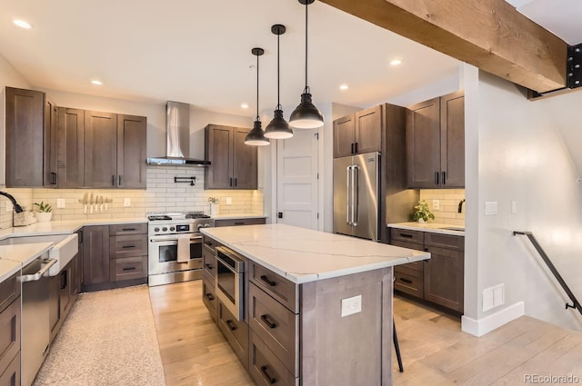 795 Pine Brook Rd, Boulder, CO 80304 - kitchen with wall chimney range hood, high quality appliances, a sink, light wood-style floors, and backsplash