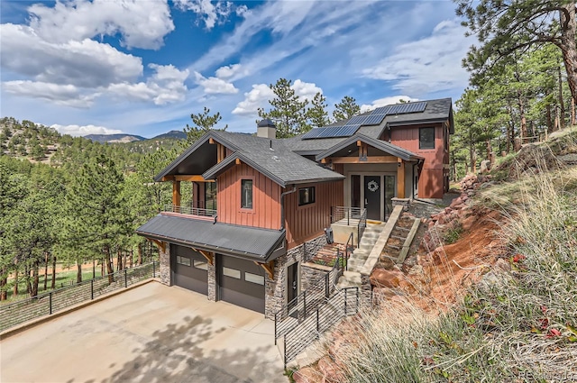 795 Pine Brook Rd, Boulder, CO 80304 - chalet / cabin featuring board and batten siding, a balcony, solar panels, concrete driveway, and stone siding