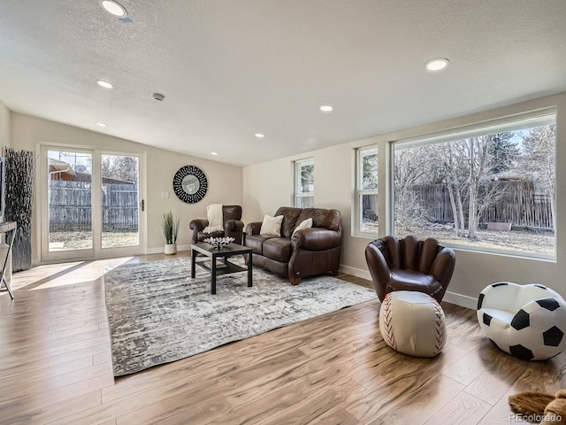 living room featuring lofted ceiling, a textured ceiling, hardwood / wood-style floors, and recessed lighting