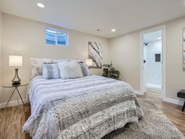 bedroom with recessed lighting, visible vents, baseboards, and wood finished floors