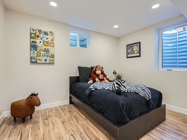 bedroom with recessed lighting, wood finished floors, and baseboards