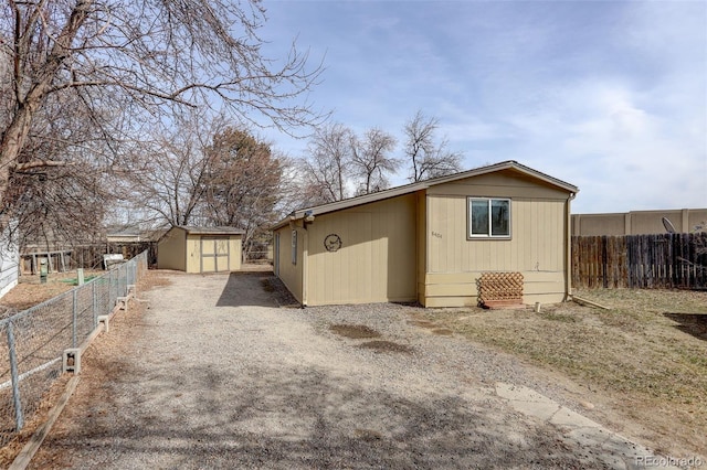 view of outdoor structure featuring an outdoor structure, driveway, and fence