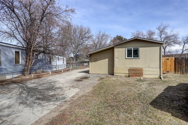 exterior space with an outbuilding, fence, and driveway