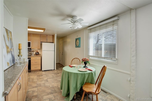 dining space featuring stone finish flooring, baseboards, and ceiling fan