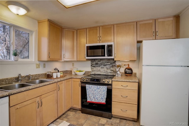 kitchen with white appliances, stone finish floor, light brown cabinets, and a sink