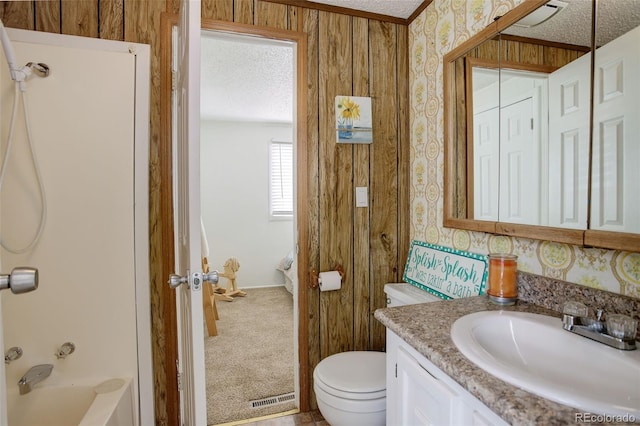 bathroom featuring toilet, a textured ceiling, shower / tub combination, wallpapered walls, and vanity