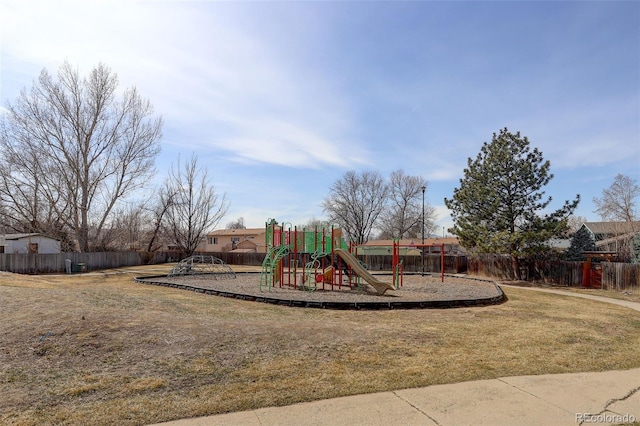 community play area featuring a yard and fence