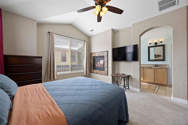 10127 Bluffmont Ln, Lone Tree, CO 80124 - bedroom with light carpet, baseboards, vaulted ceiling, ceiling fan, and ensuite bathroom