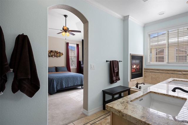 10127 Bluffmont Ln, Lone Tree, CO 80124 - bathroom featuring a glass covered fireplace, connected bathroom, crown molding, tile patterned flooring, and ceiling fan