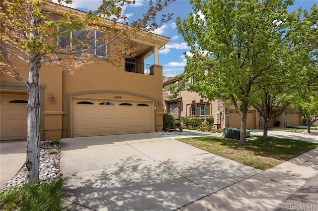 10127 Bluffmont Ln, Lone Tree, CO 80124 - view of front of house featuring stucco siding, an attached garage, a balcony, and driveway
